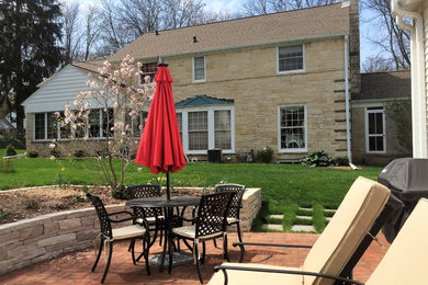 Example of a mid-sized classic backyard brick patio design in Other