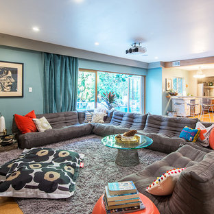 Aménagement d'une très grande salle de cinéma rétro ouverte avec un mur vert, un sol en liège, un écran de projection et un sol marron.