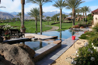 Hot tub - mid-sized tropical backyard concrete paver infinity hot tub idea in Other
