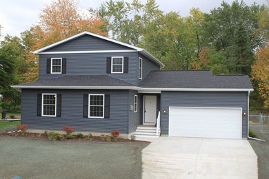 Inspiration for a mid-sized timeless blue two-story vinyl gable roof remodel in Other