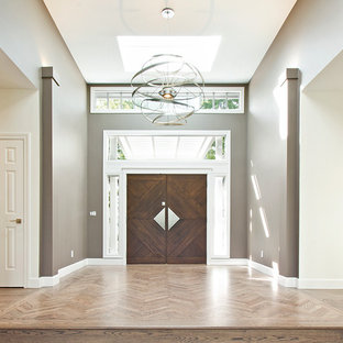 Immagine di un grande corridoio design con pareti marroni, pavimento in legno massello medio, una porta a due ante, una porta marrone e pavimento marrone