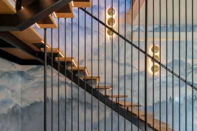 Diseño de escalera suspendida actual sin contrahuella con barandilla de metal y papel pintado