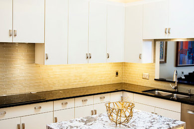 Design ideas for a mid-sized modern u-shaped separate kitchen in Minneapolis with an undermount sink, flat-panel cabinets, white cabinets, granite benchtops, beige splashback, glass tile splashback, stainless steel appliances, light hardwood floors and with island.