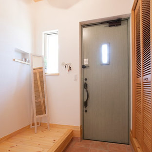 他の地域の片開きドアアジアンスタイルのおしゃれな玄関 (白い壁、テラコッタタイルの床、緑のドア、茶色い床) の写真