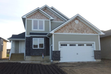 Example of a mid-sized arts and crafts green two-story concrete fiberboard gable roof design in Other