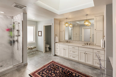 Mid-sized eclectic master bathroom in Milwaukee with recessed-panel cabinets, white cabinets, an alcove shower, a wall-mount toilet, white tile, porcelain tile, grey walls, porcelain floors, an undermount sink, engineered quartz benchtops, grey floor, a hinged shower door and white benchtops.