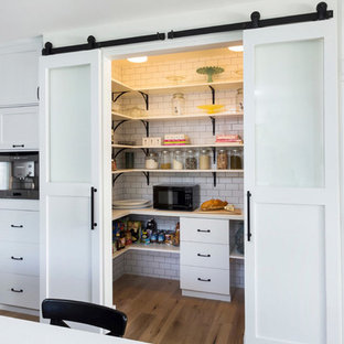 Inspiration for a scandinavian kitchen pantry in Los Angeles with open cabinets, white cabinets and light hardwood floors.