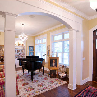 Пример оригинального дизайна интерьера: прихожая в классическом стиле с желтыми стенами и входной дверью из темного дерева