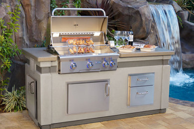 Patio kitchen - contemporary backyard concrete paver patio kitchen idea in New York