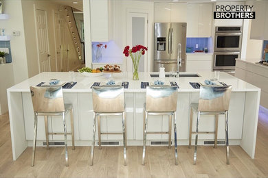 Design ideas for a large modern eat-in kitchen in New York with a double-bowl sink, flat-panel cabinets, white cabinets, quartz benchtops, blue splashback, glass tile splashback, stainless steel appliances, light hardwood floors and with island.