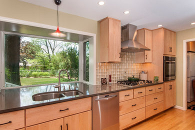 Example of a mid-sized minimalist galley light wood floor eat-in kitchen design in Indianapolis with a double-bowl sink, flat-panel cabinets, light wood cabinets, quartz countertops, glass tile backsplash and stainless steel appliances