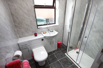 На фото: ванная комната среднего размера в современном стиле с белыми фасадами, угловым душем, серыми стенами, полом из сланца, душевой кабиной, монолитной раковиной, серым полом и душем с раздвижными дверями с