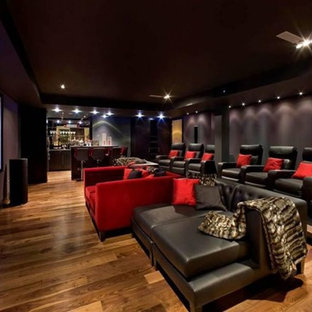 Example of a huge minimalist open concept medium tone wood floor home theater design in Las Vegas with purple walls and a projector screen