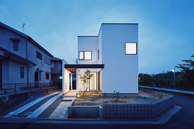 Idées déco pour une façade de maison blanche moderne en stuc avec un toit en appentis.