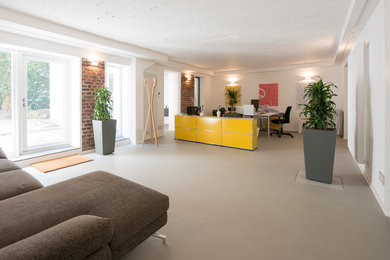 Großes Industrial Arbeitszimmer mit Betonboden, grauem Boden, Arbeitsplatz und weißer Wandfarbe in Köln