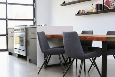 Example of a small minimalist galley concrete floor and gray floor open concept kitchen design in Other with flat-panel cabinets, concrete countertops, stainless steel appliances, an island, brown cabinets, a single-bowl sink and white backsplash