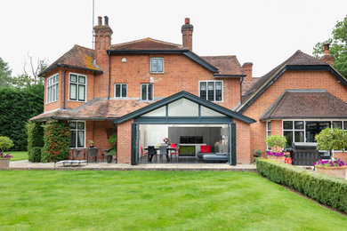 Photo of a medium sized modern split-level brick and rear house exterior in Berkshire.