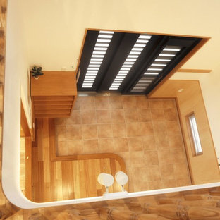 他の地域の引き戸アジアンスタイルのおしゃれな玄関ホール (セラミックタイルの床、黒いドア、ターコイズの床) の写真