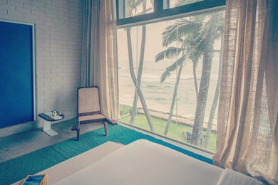 Mid-sized beach style guest concrete floor bedroom photo in Other with white walls