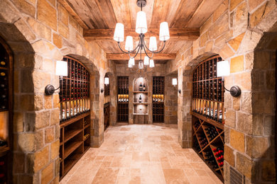 Mid-sized elegant travertine floor and beige floor wine cellar photo in New York with storage racks