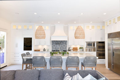 Kitchen - large coastal kitchen idea in Orange County with shaker cabinets, white cabinets and an island