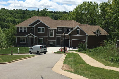 Inspiration for a large timeless brown two-story exterior home remodel in Other with a shingle roof