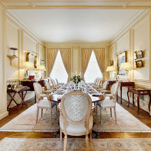 Пример оригинального дизайна: большая гостиная-столовая в классическом стиле с желтыми стенами, стандартным камином, фасадом камина из камня и паркетным полом среднего тона