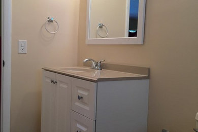 Example of a mid-sized trendy beige tile and ceramic tile ceramic tile drop-in bathtub design in Miami with white cabinets, a two-piece toilet, beige walls and an undermount sink