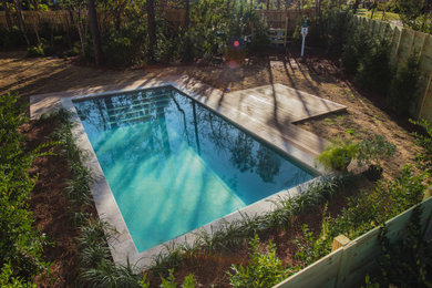 Example of a small trendy backyard rectangular natural pool design in Other with decking