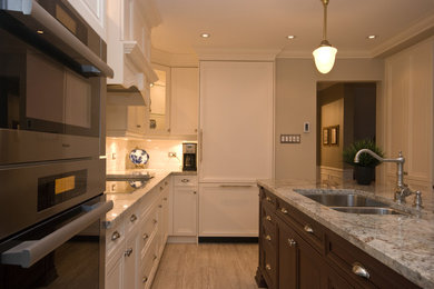Mid-sized elegant l-shaped light wood floor eat-in kitchen photo in Toronto with an undermount sink, recessed-panel cabinets, white cabinets, granite countertops, white backsplash, subway tile backsplash, paneled appliances and an island