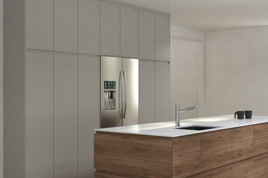 Example of a mid-sized danish galley light wood floor enclosed kitchen design with an undermount sink, flat-panel cabinets, medium tone wood cabinets, marble countertops, stainless steel appliances, an island and white countertops
