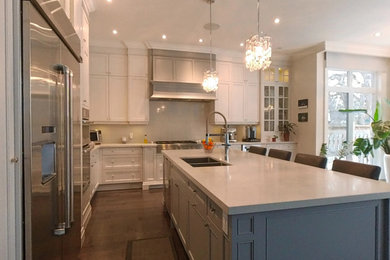 Example of a large transitional dark wood floor and brown floor kitchen design in Toronto with an undermount sink, white cabinets, quartz countertops, white backsplash, quartz backsplash, stainless steel appliances, an island and white countertops