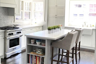 Example of a small transitional u-shaped dark wood floor and brown floor open concept kitchen design in Toronto with a farmhouse sink, shaker cabinets, white cabinets, quartz countertops, gray backsplash, stone tile backsplash, stainless steel appliances and an island