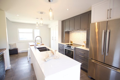 Mid-sized minimalist ceramic tile kitchen photo in Montreal with an integrated sink, shaker cabinets, white cabinets, quartzite countertops, white backsplash, stainless steel appliances and an island