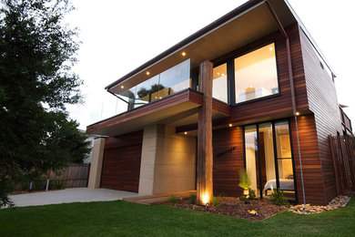 Photo of a mid-sized contemporary two-storey exterior in Melbourne with wood siding.