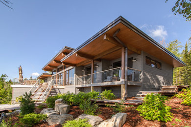 Inspiration for a mid-sized contemporary gray one-story wood exterior home remodel in Other with a black roof