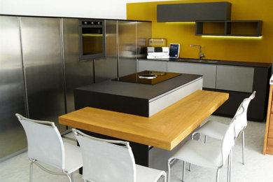 Immagine di una cucina industriale con lavello a doppia vasca e ante grigie