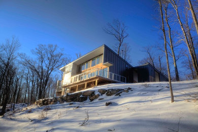 Inspiration for a mid-sized modern brown two-story wood house exterior remodel in Philadelphia with a shed roof and a metal roof