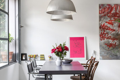 Photo of an industrial dining room in Milan with concrete floors, grey floor and white walls.