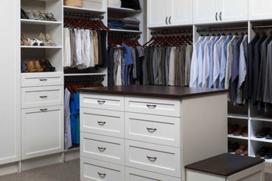 This is an example of a large gender-neutral walk-in wardrobe in Sacramento with shaker cabinets, white cabinets and carpet.