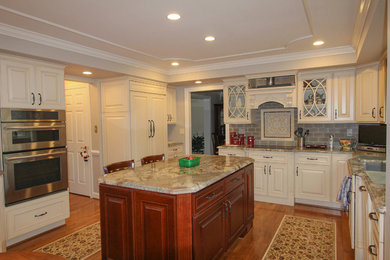 Inspiration for a huge contemporary galley light wood floor kitchen pantry remodel with an undermount sink, raised-panel cabinets, white cabinets, solid surface countertops, gray backsplash, ceramic backsplash, stainless steel appliances and an island