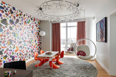 Design ideas for a large contemporary gender-neutral kids' room in New York with multi-coloured walls and light hardwood floors.
