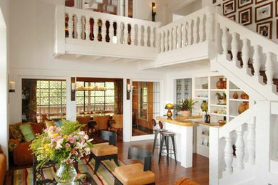 Large elegant open concept medium tone wood floor living room photo in San Francisco with a bar and white walls
