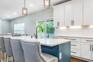 Inspiration for a timeless brown floor eat-in kitchen remodel in Boston with white cabinets and an island
