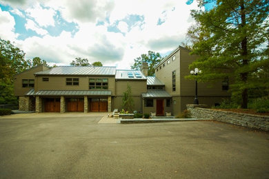 Large transitional brown two-story concrete fiberboard house exterior photo in Cincinnati with a metal roof and a shed roof