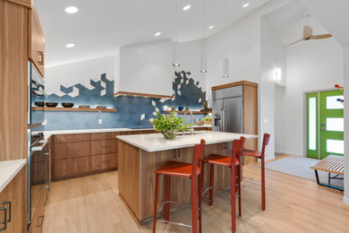 Eat-in kitchen - huge 1960s u-shaped light wood floor, brown floor and vaulted ceiling eat-in kitchen idea in Portland with a drop-in sink, flat-panel cabinets, dark wood cabinets, quartz countertops, blue backsplash, ceramic backsplash, stainless steel appliances, an island and white countertops