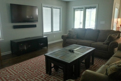 Inspiration for a home cinema in Columbus with grey walls, medium hardwood flooring and a wall mounted tv.