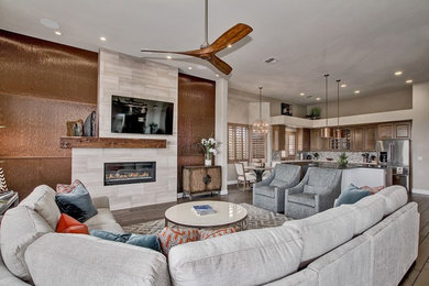 This is an example of a mid-sized contemporary open concept family room in Phoenix with grey walls, medium hardwood floors, a ribbon fireplace, a stone fireplace surround and no tv.