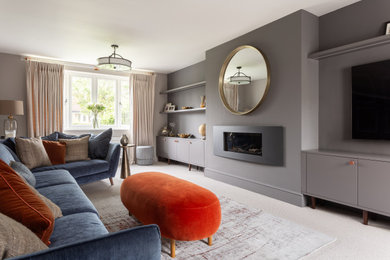 Photo of a medium sized midcentury living room in Other with grey walls, carpet, a standard fireplace, a wall mounted tv and feature lighting.
