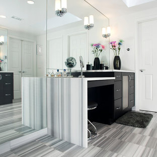 Immagine di una grande stanza da bagno padronale moderna con ante lisce, ante nere, lavabo sottopiano, top in laminato, doccia ad angolo, WC a due pezzi, pareti bianche, pavimento in gres porcellanato, pavimento grigio e porta doccia a battente